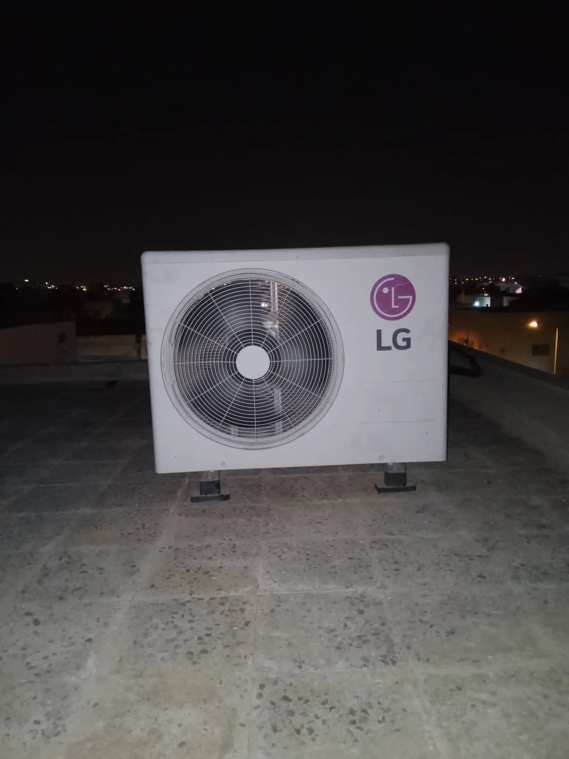 وحدة تكييف خارجية على سطح منزل في الليل
